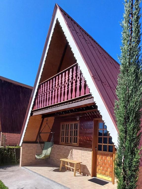 a house with a red roof and a picnic table at Recanto Mauá - Chalé Amarílis in Resende