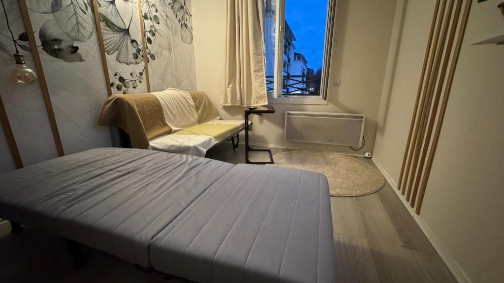 a small room with a bed and a chair at Paris Home in Bussy-Saint-Georges