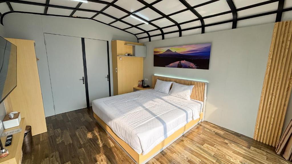 a bedroom with a bed and a painting on the wall at The Lakebox Menjer by Travelink in Garung