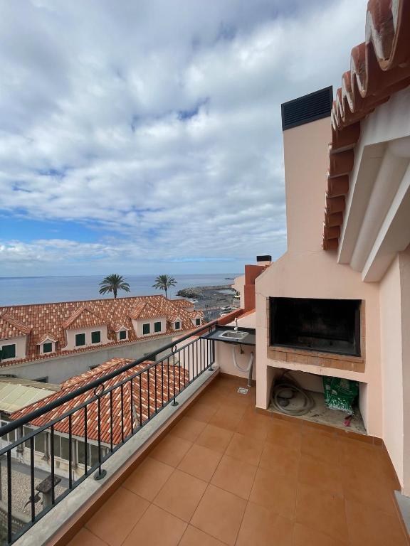 a balcony with a fireplace and a view of the ocean at Ribeira brava - duplex sea view in Ribeira Brava