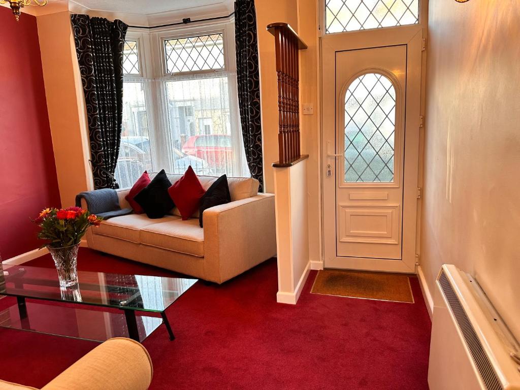 a living room with a couch and a table and a door at Private Rooms in Portsmouth in Portsmouth