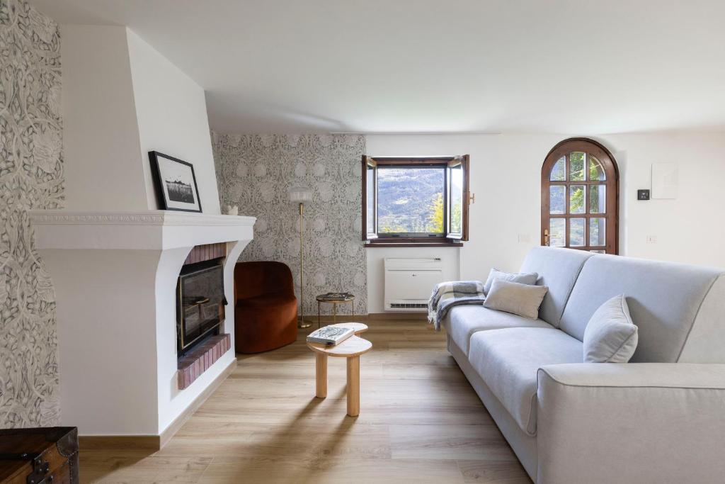 un salon avec un canapé et une cheminée dans l'établissement Maison Carola Sous Les Étoiles, à Aoste