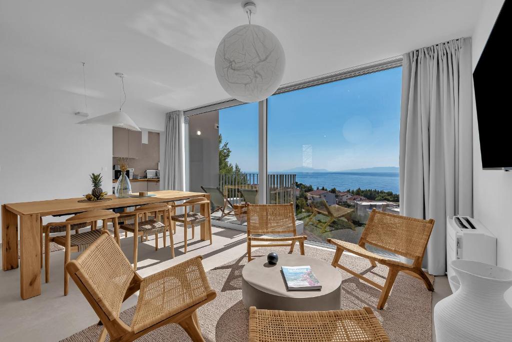 een woonkamer met een tafel en stoelen en een groot raam bij Vista Divina - Semi Detached Vacation Homes by Irundo in Zavala