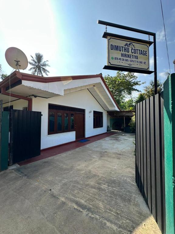 un bâtiment avec une clôture devant lui dans l'établissement Dimuthu Cottage Hiriketiya, à Dikwella