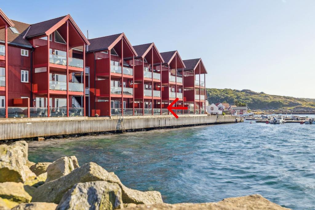 een rood gebouw naast een waterlichaam bij Apartment in beautiful Korshamn by the sea in Korshamn