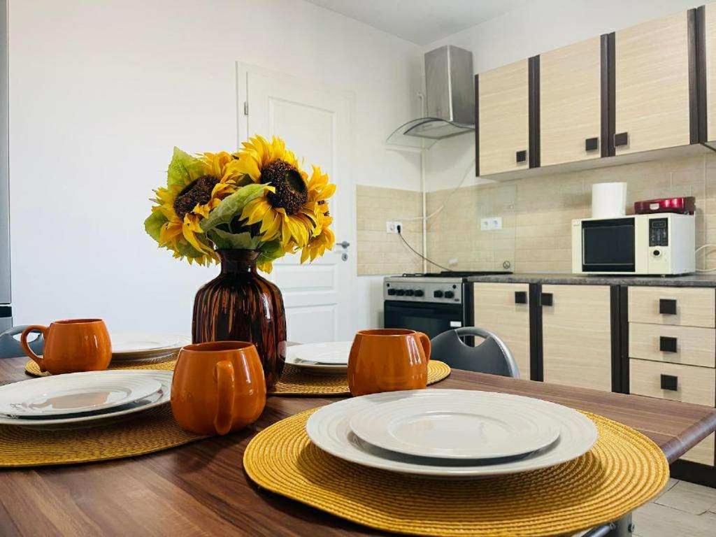 een tafel met een vaas met zonnebloemen in een keuken bij Oty Residence Iasi in Iaşi