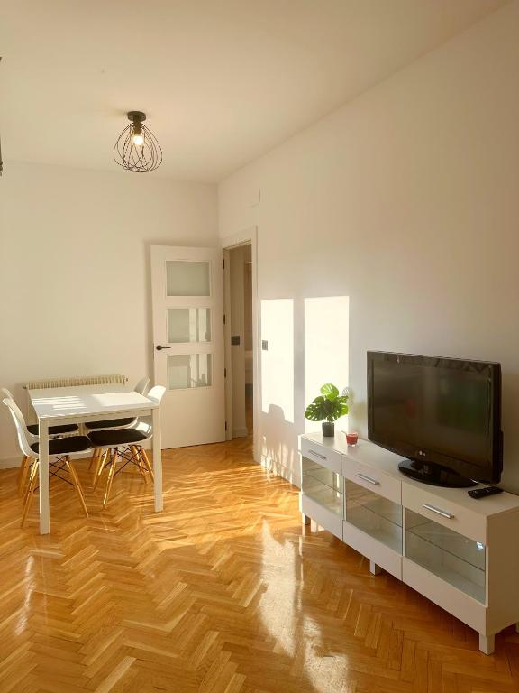 a living room with a television and a dining table at VUT Torreón de los Guzmanes in Ávila