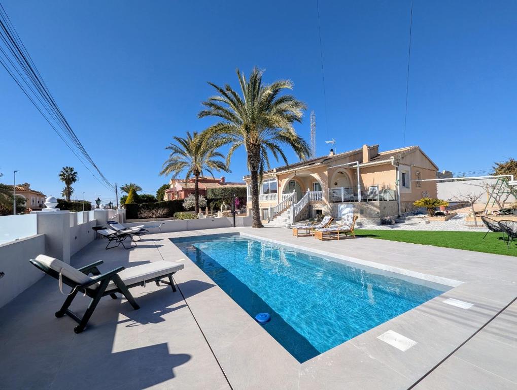 a villa with a swimming pool and a house at R-70 Oasis in Ciudad Quesada