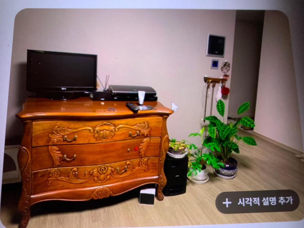 a wooden dresser with a television on top of it at 혼자 여행하는 여성을 위한 안전한 숙소 