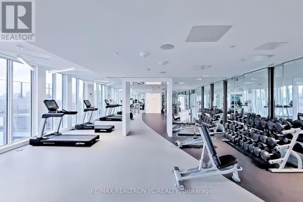 a gym with rows of treadmills and machines at Cozy holiday home in Toronto