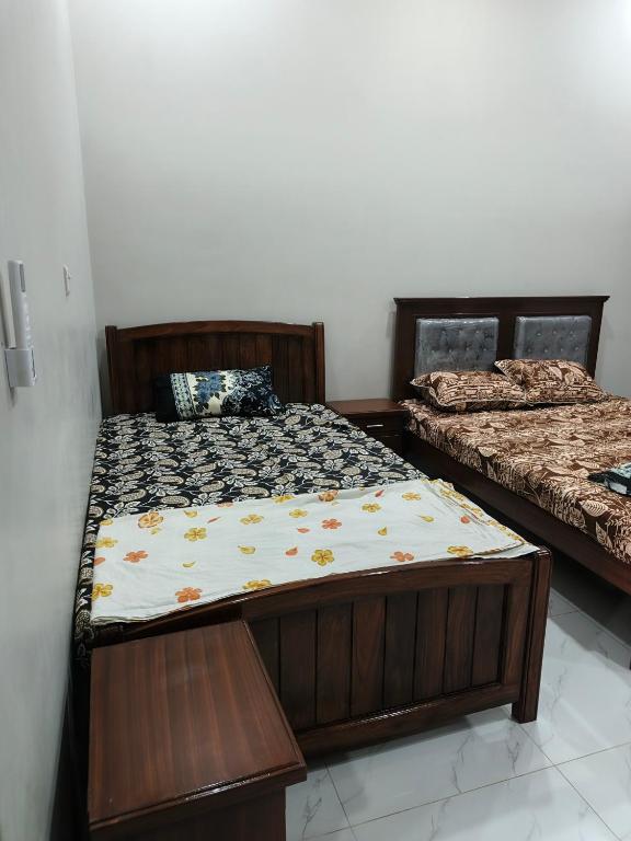 Dos camas una al lado de la otra en una habitación. en Marhaba Guest House Multan, en Multán