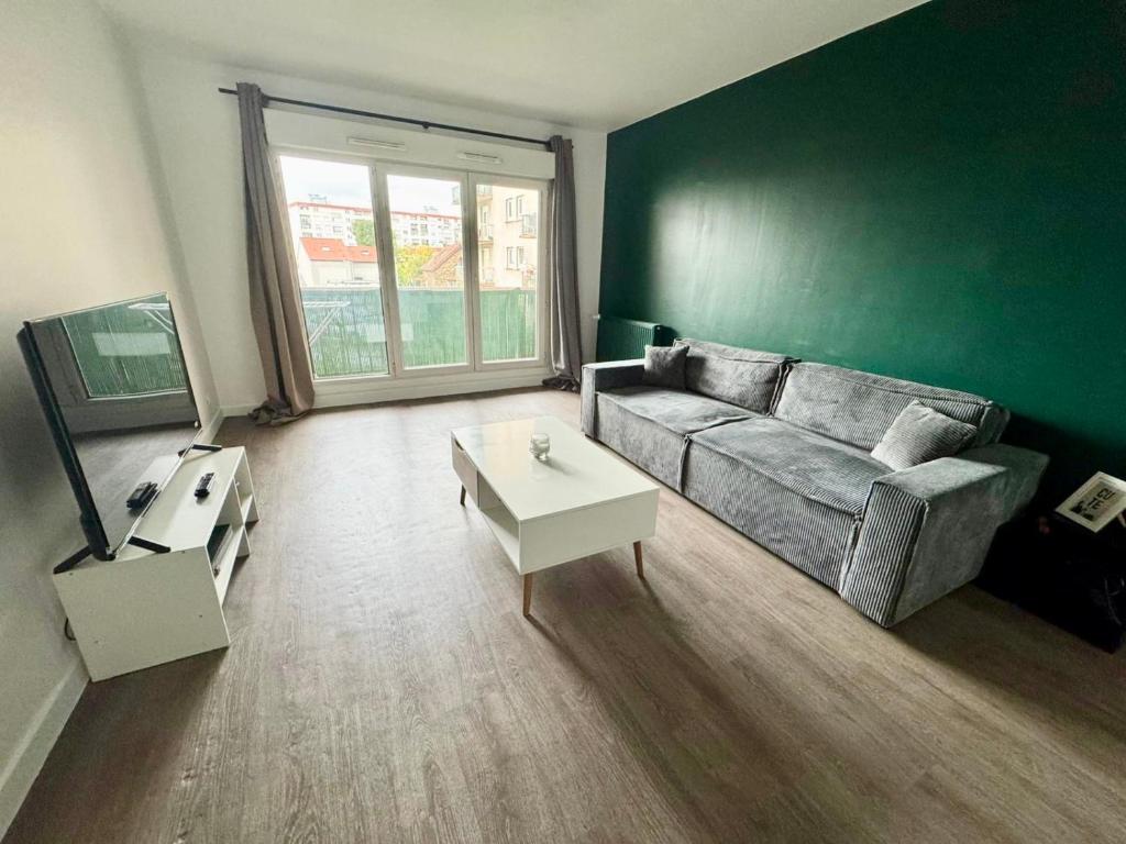 a living room with a couch and a table at Le Vilmorin - Balcon - 4 prs - Proche Paris in Vitry-sur-Seine