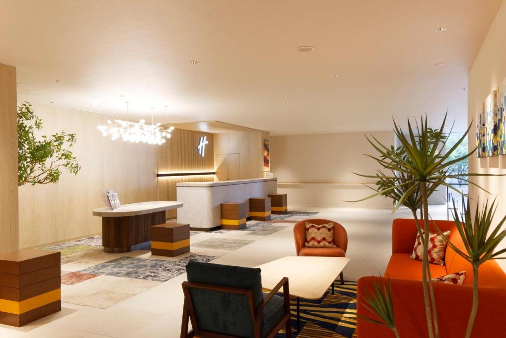 Holiday Inn & Suites Sapporo Odori Park by IHG في سابورو: غرفة معيشة مع طاولة وكراسي