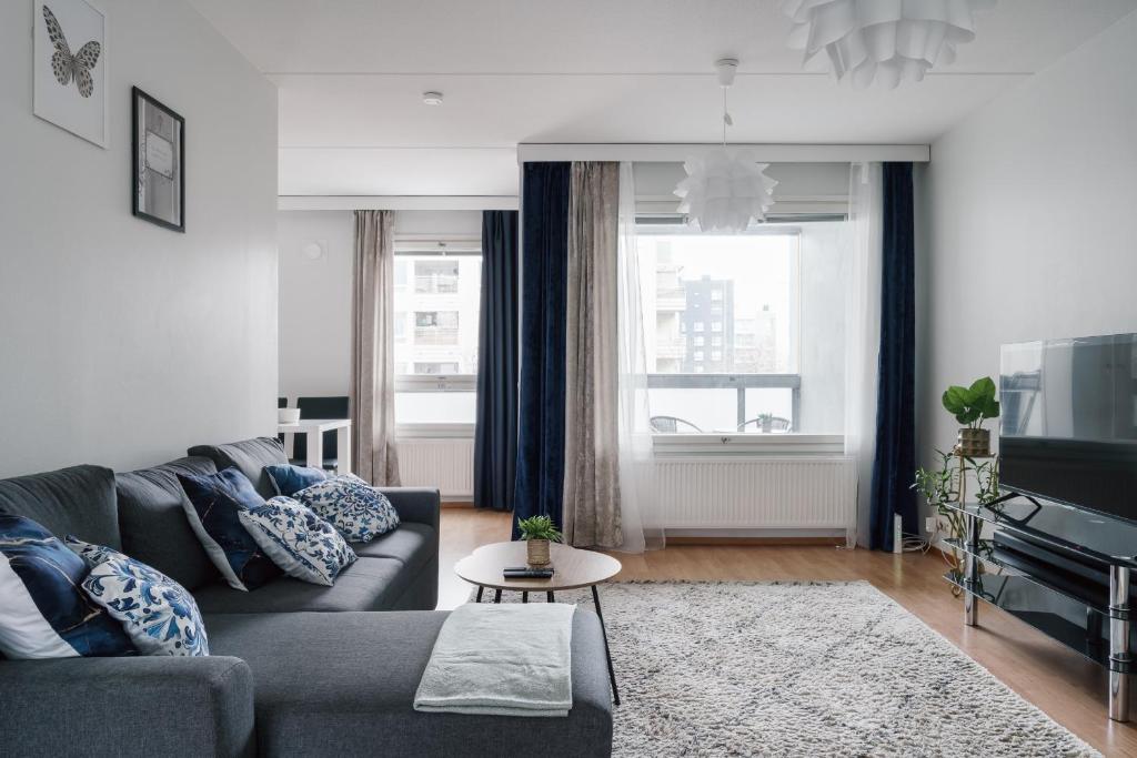 een woonkamer met een bank en een tv bij Spacious City Retreat with Private Sauna in Helsinki