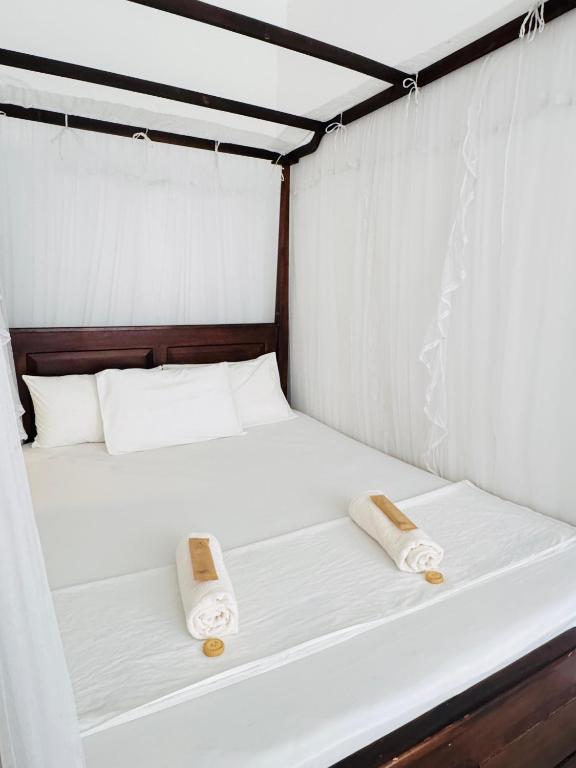two beds in a room with two towels on them at Aloe villa in Weligama