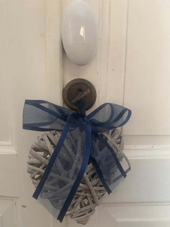a basket with a blue ribbon and a balloon on a door at Parva Domus Intera casa indipendente in centro in Modica