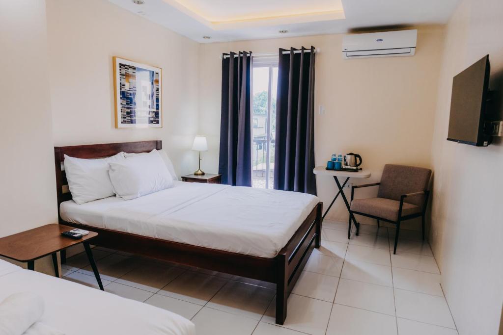 a hotel room with a bed and a chair at Nine Balconies Island Stay in Boac