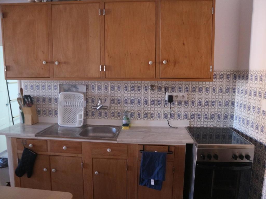 a kitchen with wooden cabinets and a counter top at Toca da raposa in Raposeira