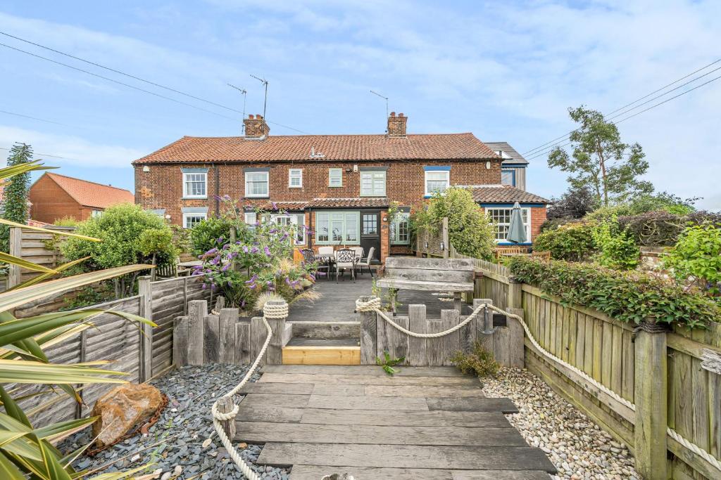 a house with a wooden fence and a wooden stairs at Sunset View in Thornham