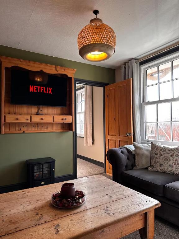 a living room with a couch and a table at The Hideaway in Stratford-upon-Avon