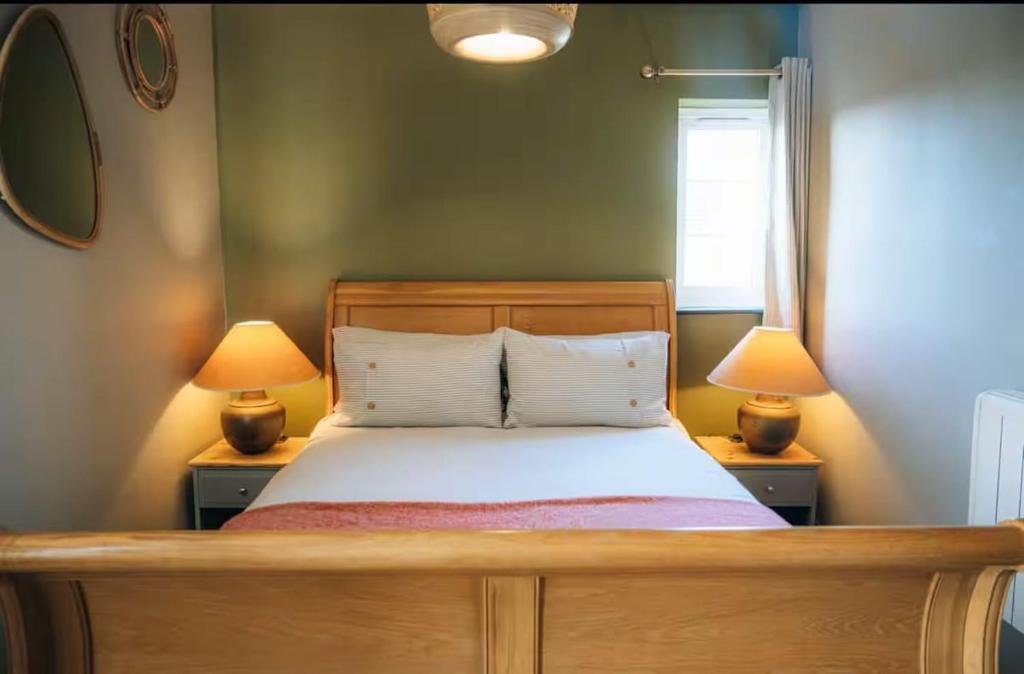 a bedroom with a bed with two lamps on tables at The Hideaway in Stratford-upon-Avon