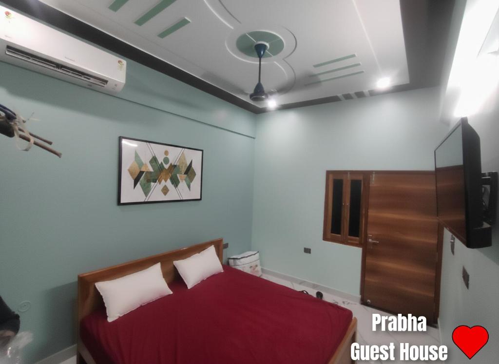 a bedroom with a bed and a ceiling fan at Prabha Guest House Ayodhya in Ayodhya