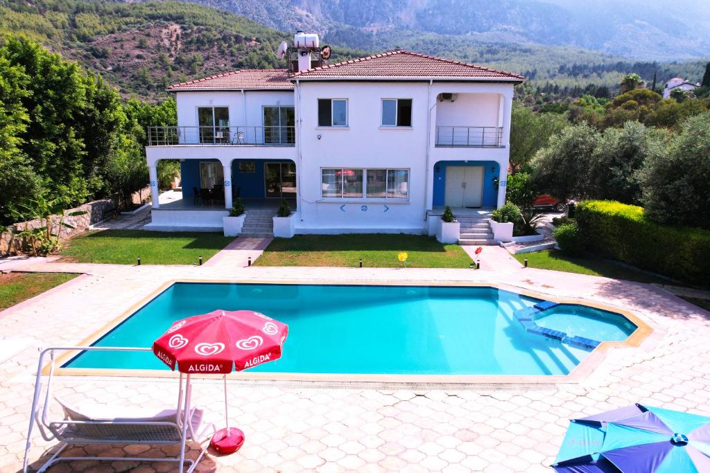 eine Villa mit Swimmingpool und ein Haus in der Unterkunft Villa Olivia in Lapithos