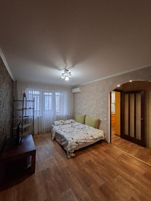 a bedroom with a bed and a wooden floor at Апартаменти біля Автовокзалу in Kryvyi Rih