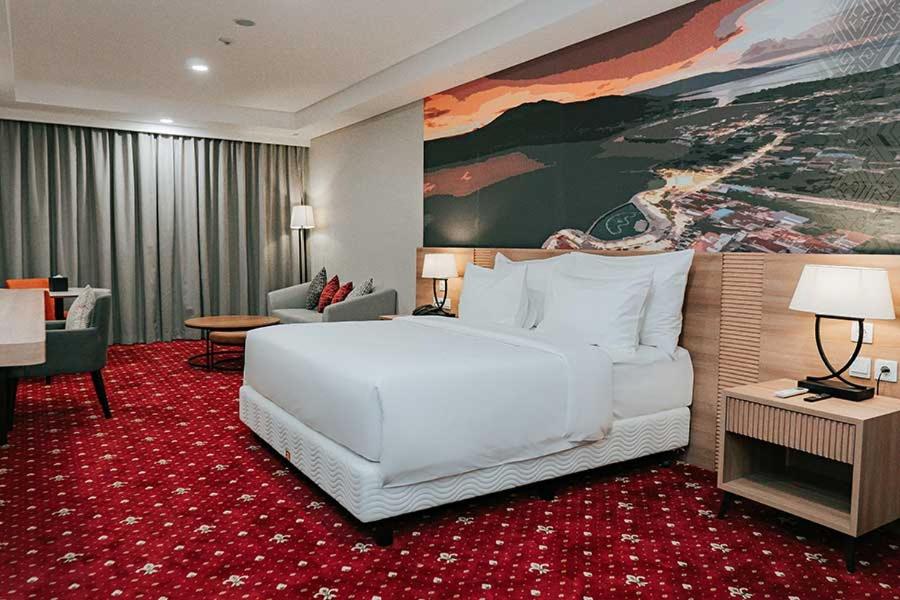 a large white bed in a hotel room at Marianna Resort & Convention Tuktuk - Samosir, Marclan Collection in Ambarita