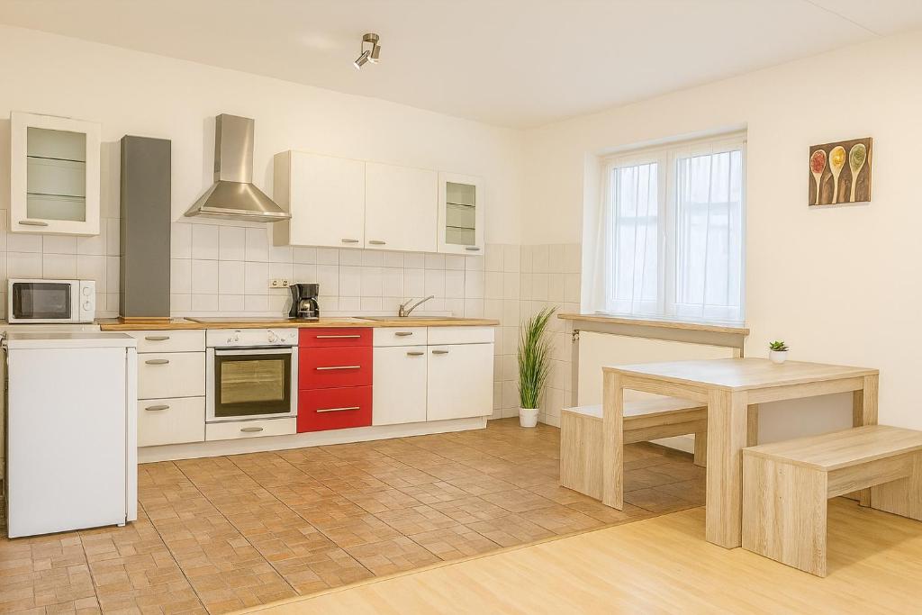 a kitchen with white cabinets and a wooden table at SUNNYHOME Monteurwohnungen und Apartments in Schwandorf in Schwandorf in Bayern