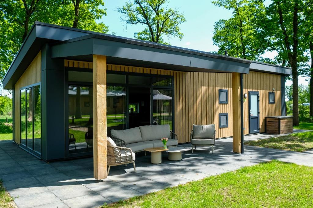 a large shed with a couch and two chairs at Vakantiepark de Witte Berg in Ootmarsum