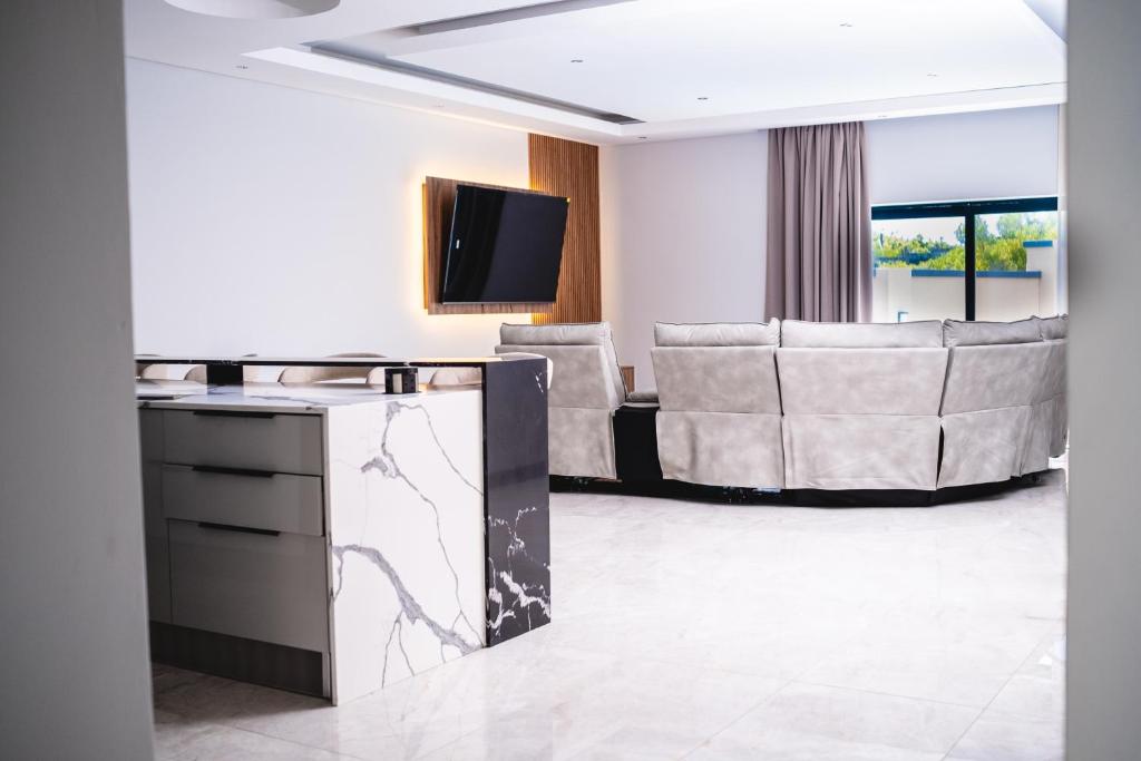 a living room with a couch and a tv at Santareme Breeze in Sea Vista