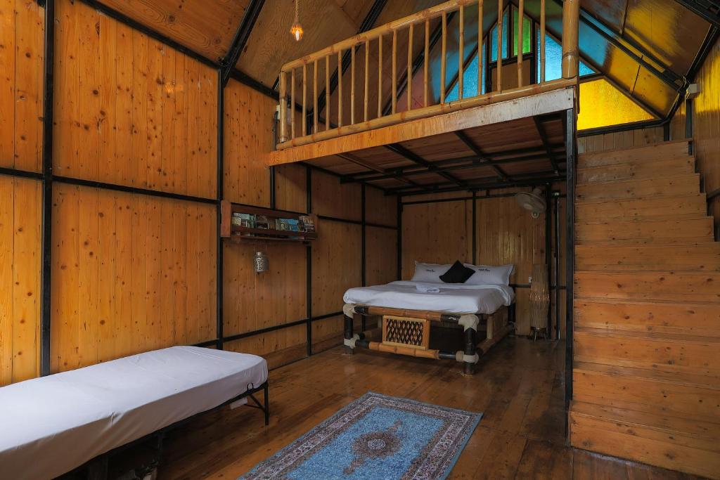 een kamer met twee bedden in een houten hut bij The Buddha Village in Chik Ballāpur