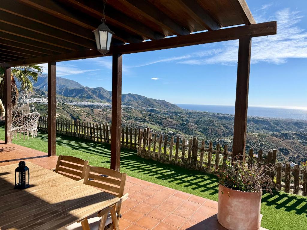 un patio con mesa y vistas a las montañas en Vela Luka Frigiliana, en Frigiliana
