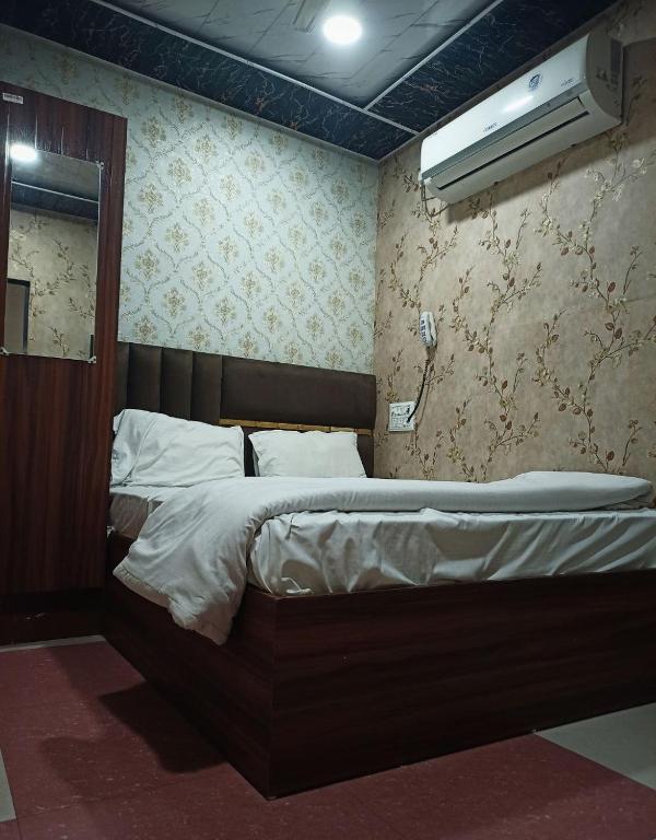 a bedroom with a bed in a room with aperature at Manya hotel and dormitory in Jhānsi