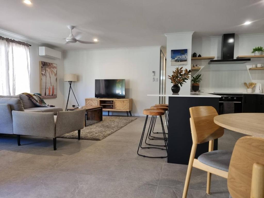 un salon avec un canapé et une table dans l'établissement SeaEstaAtMoffatQuietbeachParklargefenced yard, à Caloundra