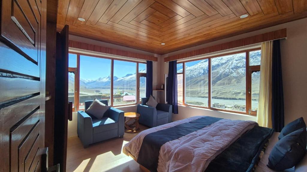 a bedroom with a bed and a view of a mountain at The White Mountain Stays in Kibar