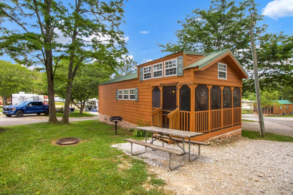 a tiny house with a picnic table and a bench at Jellystone Mammoth Cave in Cave City