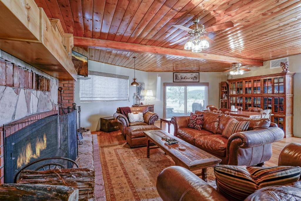 a living room with leather furniture and a large fireplace at Wild Bill Retreat Treehouse Acre of Fun Near Grand Canyon Williams in Williams