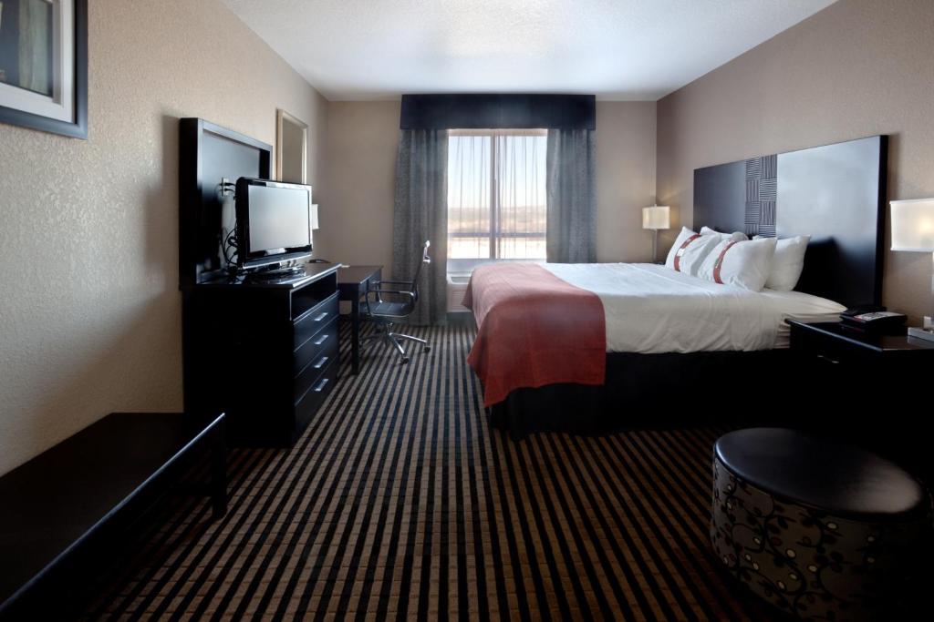 a hotel room with a bed and a television at Holiday Inn San Antonio North Stone Oak Area by IHG-Newly Renovated in San Antonio
