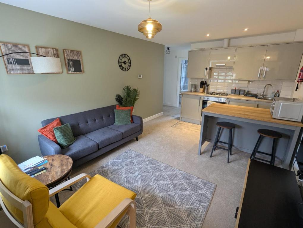 a living room with a couch and a table and a kitchen at Ruskin Apartment - Free Parking - 2 Bedrooms - Sleeps 3 in Midsomer Norton
