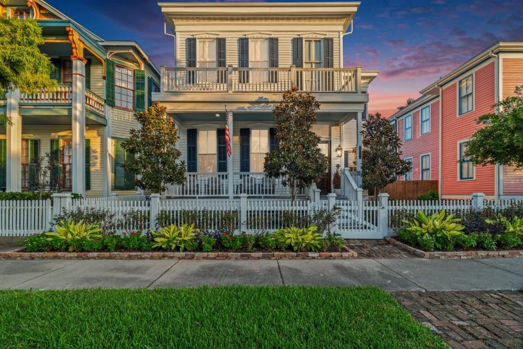 une rangée de maisons avec une clôture blanche dans l'établissement The White Pelican Inn-Trolley a 5 Minute Walk Stops at SeawallBeach, à Galveston