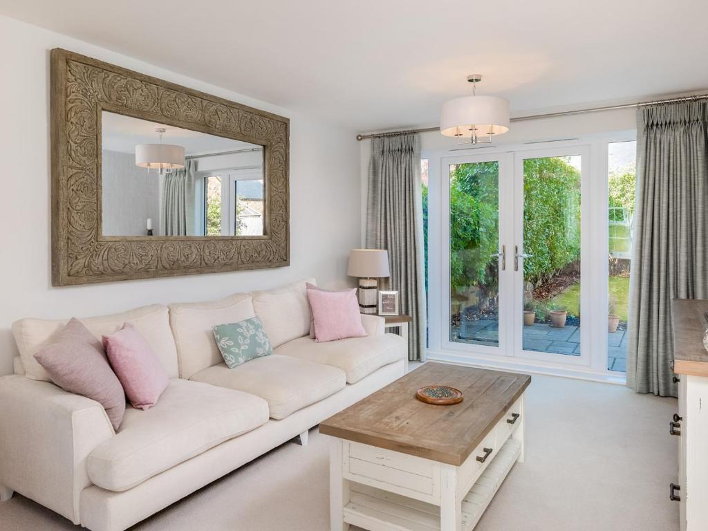 a living room with a white couch and a mirror at Pass the Keys Former Show Home 6 min walk to Deddington in Deddington