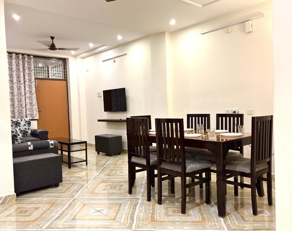ein Esszimmer mit Tisch und Stühlen und einer Couch in der Unterkunft SR Homes - Your Gateway to Hyderabad in Hyderabad