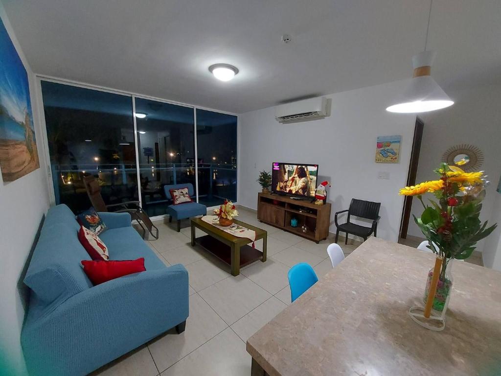 un salon avec un canapé bleu et une table dans l'établissement Playa Blanca Beach and Lagoon Residences, à Cruce del Farallón