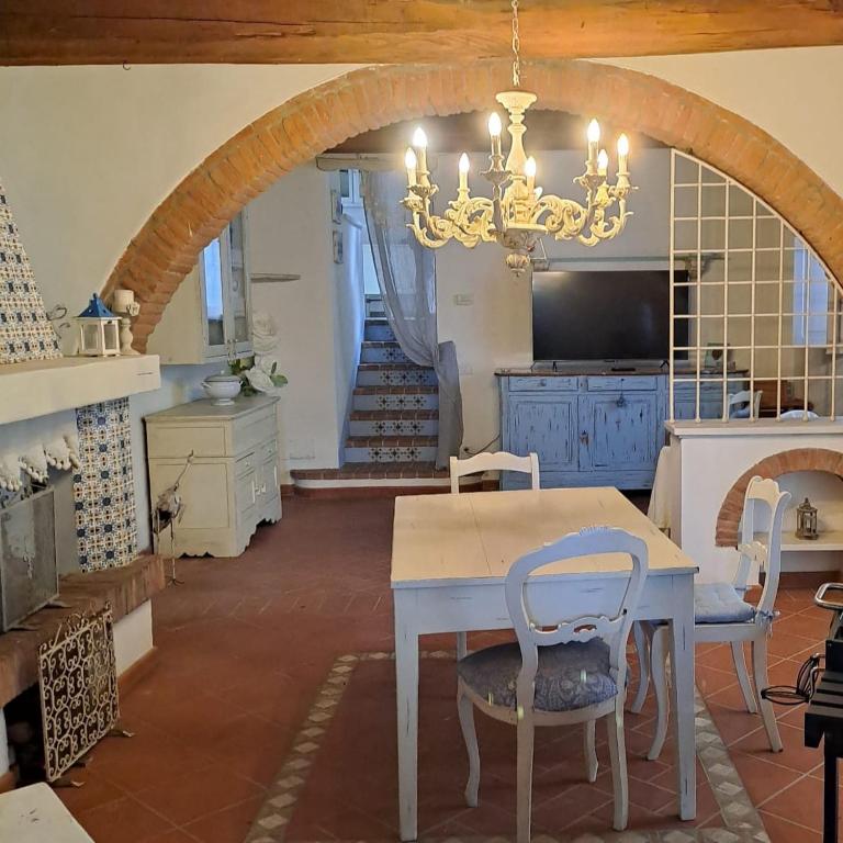 a dining room with a table and a chandelier at Emozioni Di Campagna in Palaia