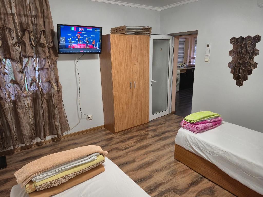 a room with two beds and a flat screen tv at Guest House Valchanovi in Elkhovo