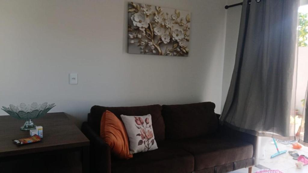 uma sala de estar com um sofá e um quadro na parede em Perto da área central em Sinop