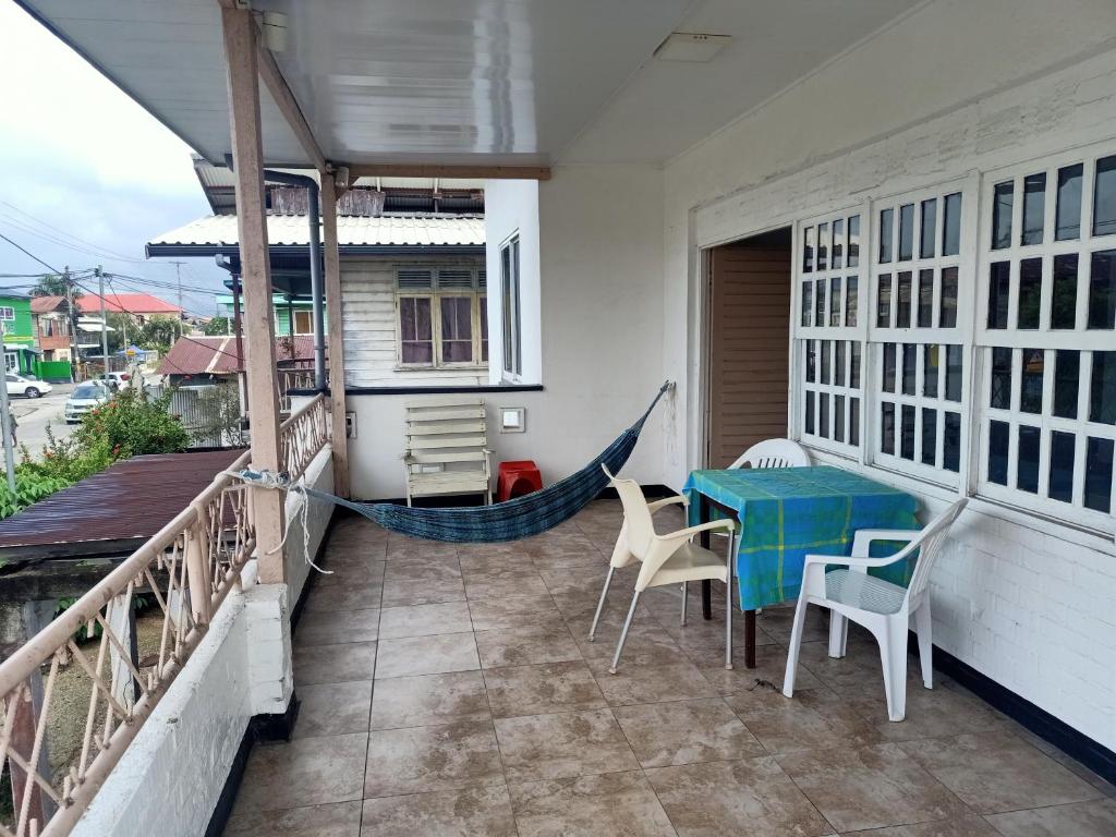 - une terrasse couverte avec un hamac, une table et des chaises dans l'établissement Bovenhuis Masusa, à Paramaribo