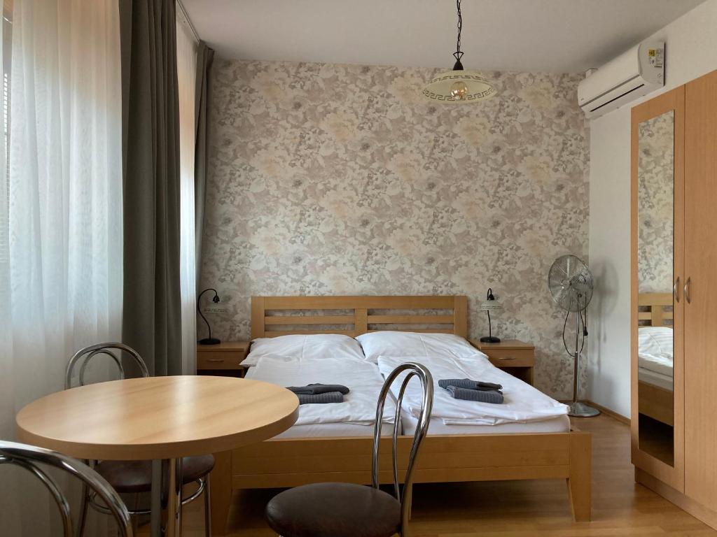 a bedroom with a bed and a table and a table and chairs at Penzion U Radnice in Kyjov